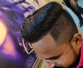 Stylist giving haircut to a male customer