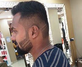 Stylist giving haircut to a male customer